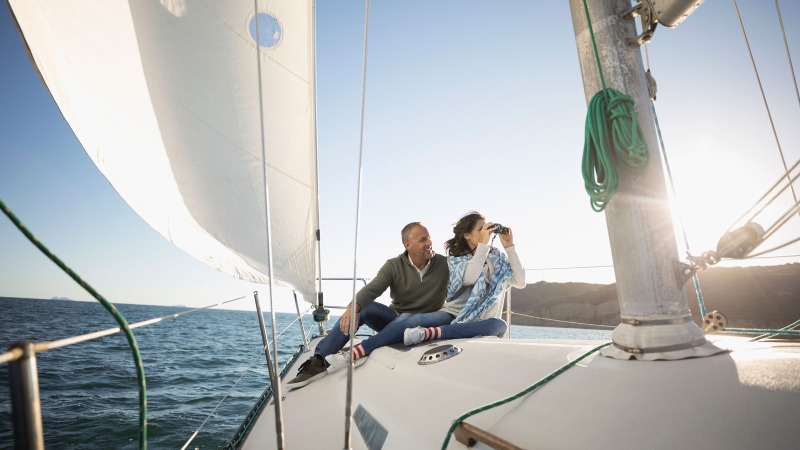 A man and a woman enjoying traveling by yacht