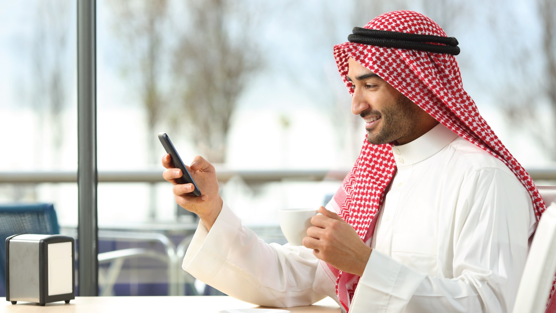 Saudi man holding his phone