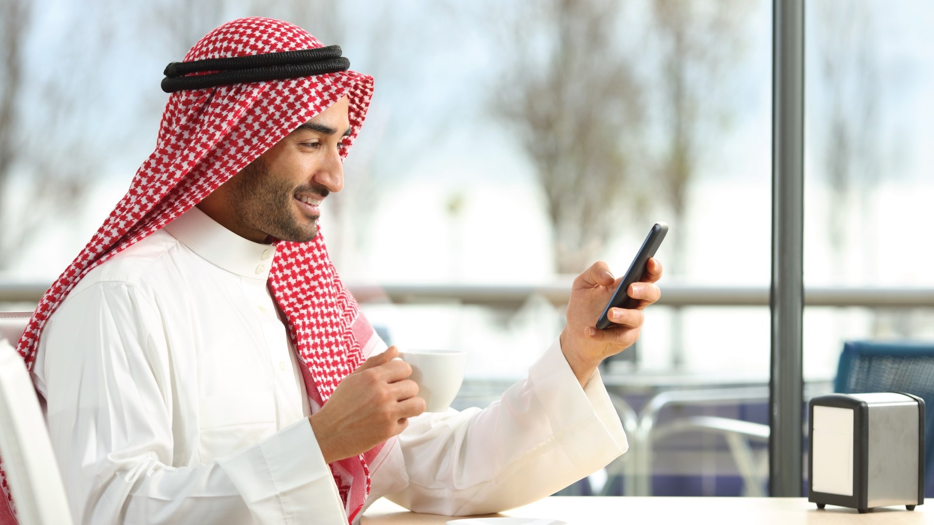 Saudi man holding his phone