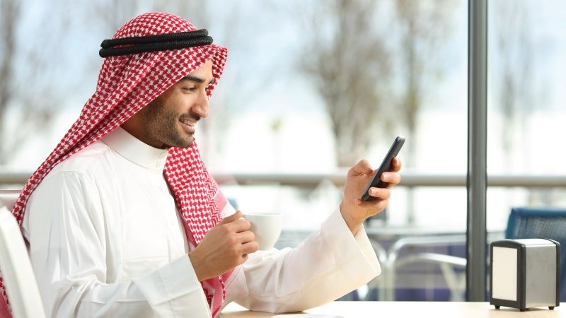 Saudi man holding his phone