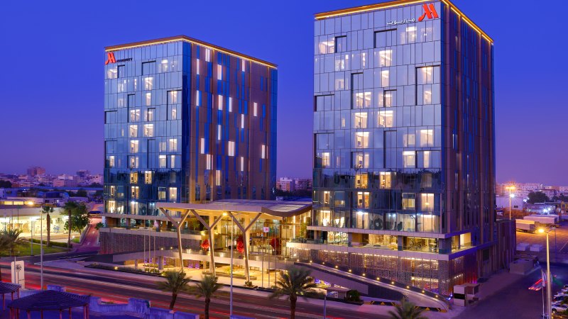 Modern Jeddah Marriott Hotel Madinah Road illuminated at night with twin glass towers.